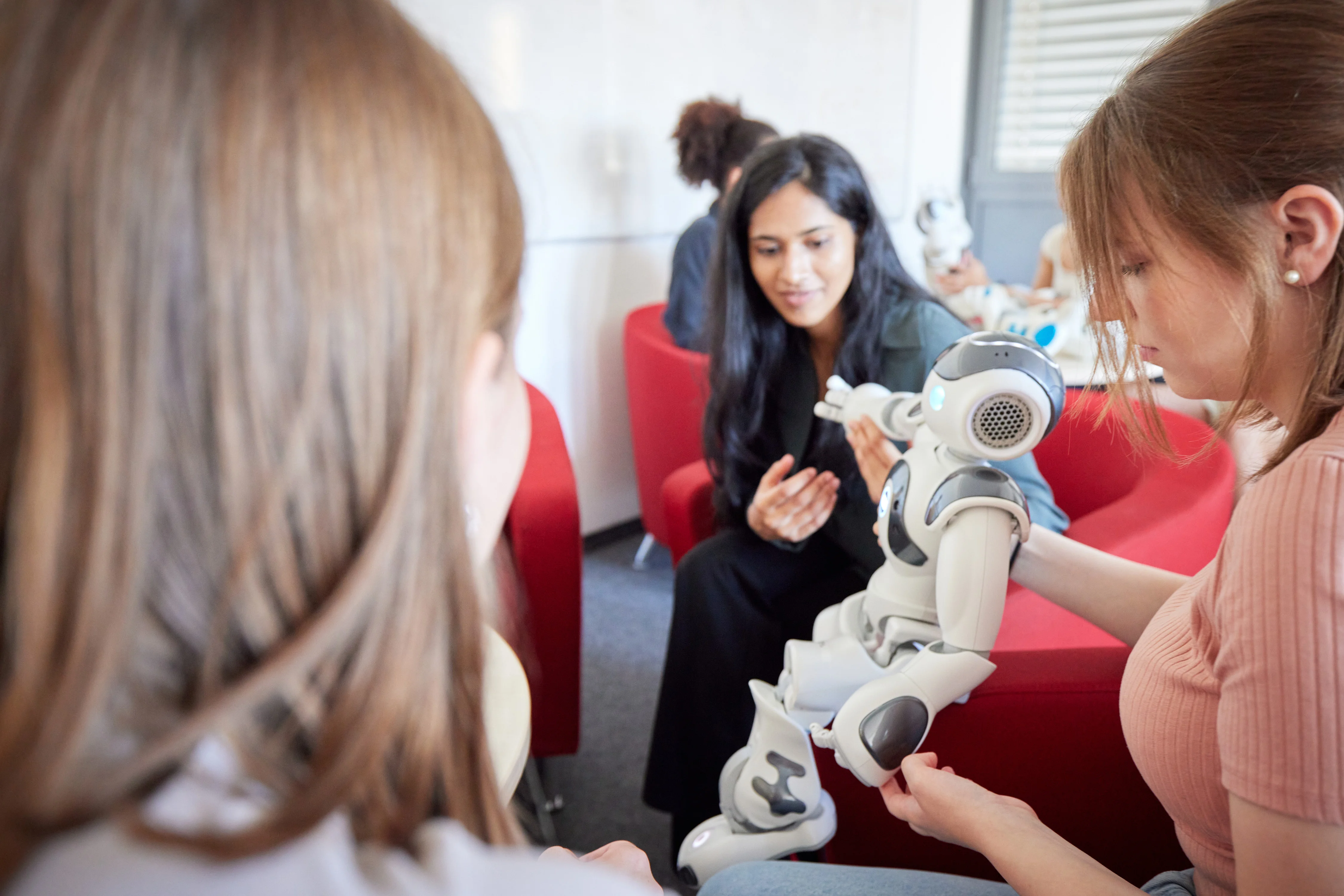 Eine Gruppe von Frauen bewegt einen menschenähnlichen Roboter.